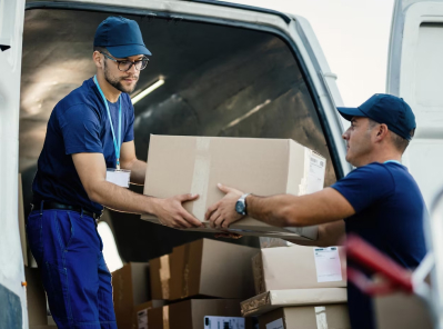 Two movers handling cardboard boxes in a moving van, representing Octopus Moving Company's services in Milton, Massachusetts.