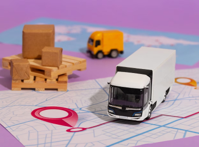 Model moving truck on a map with location pin, surrounded by wooden blocks and a toy truck, representing Octopus Moving Company's long-distance moving services from Boston to Los Angeles.