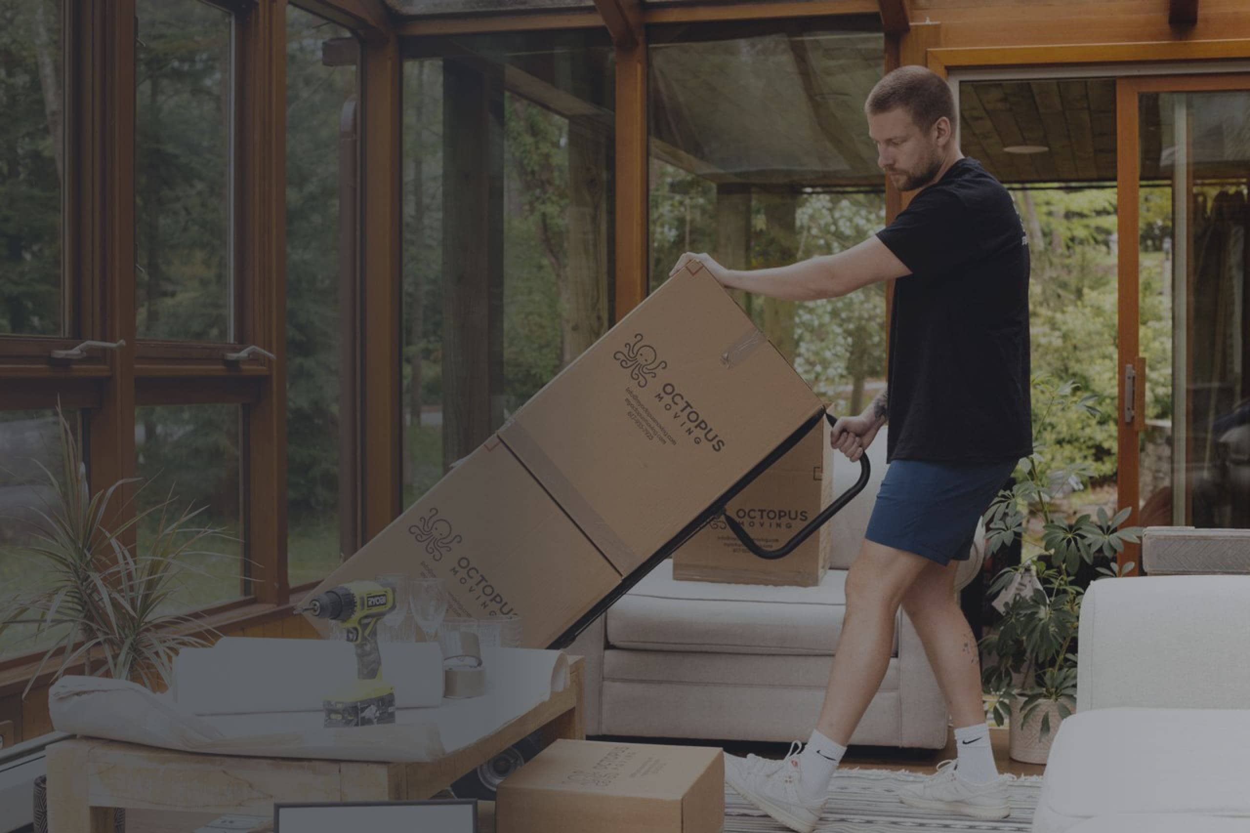 Man carrying Octopus Moving boxes in a home setting, showcasing moving services and packing assistance in Providence, Rhode Island.