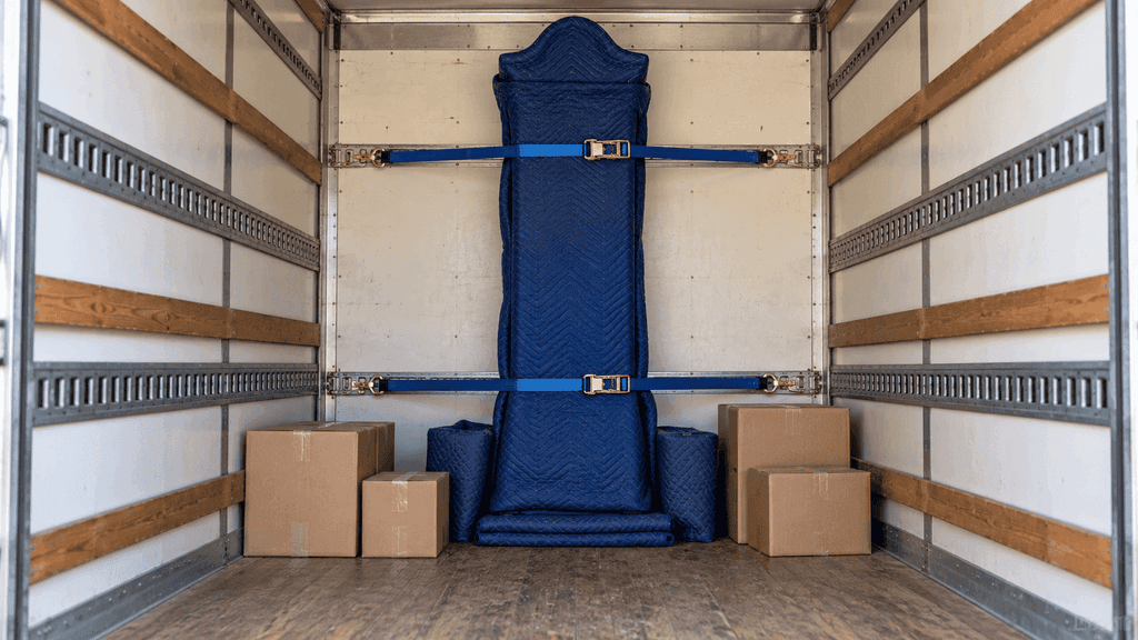 Wrapped grandfather clock strapped upright inside a moving truck